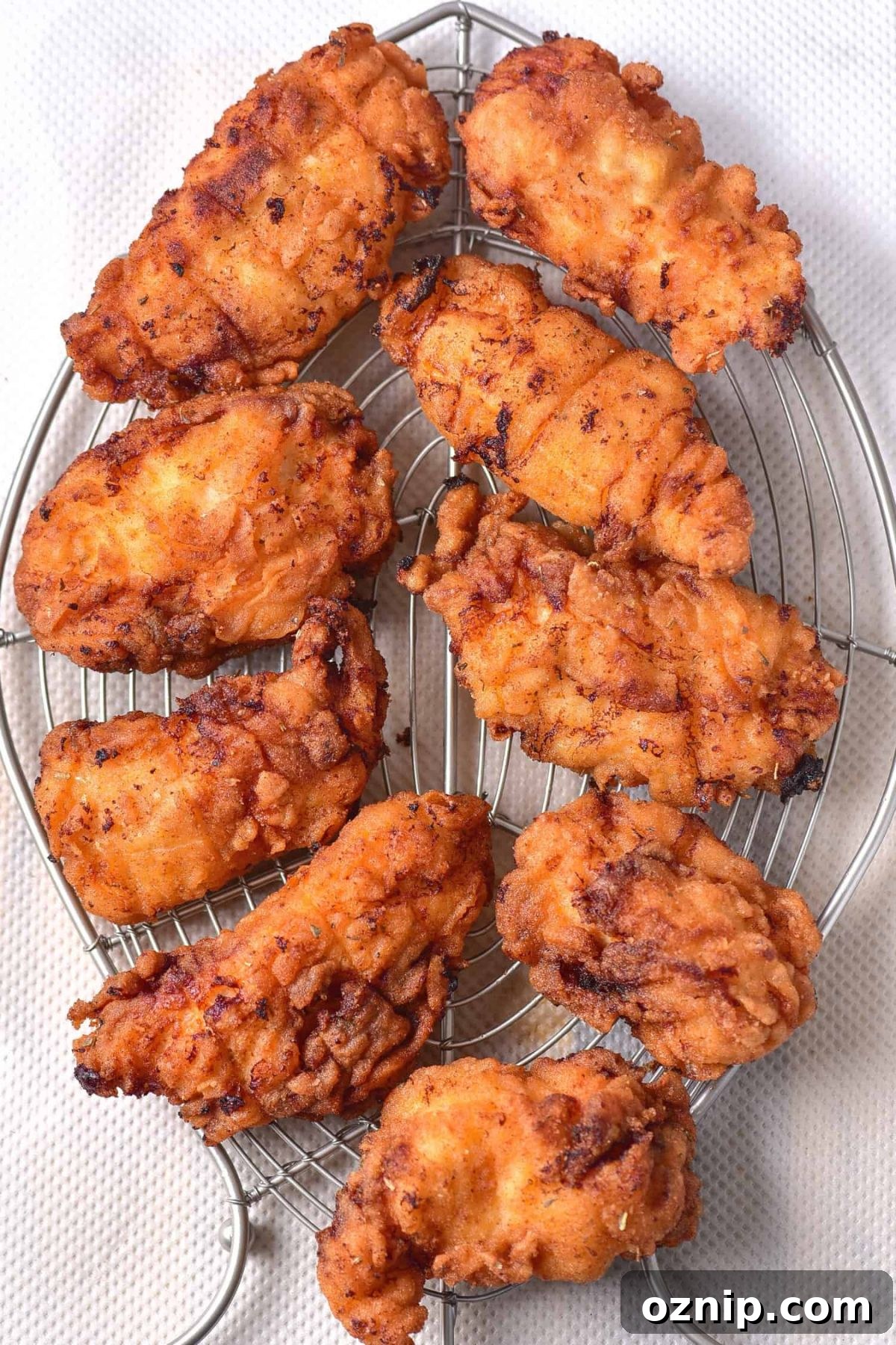 Gluten-Free Dairy-Free Fried Chicken Breast Dairy-free fried chicken cooling on wire rack.