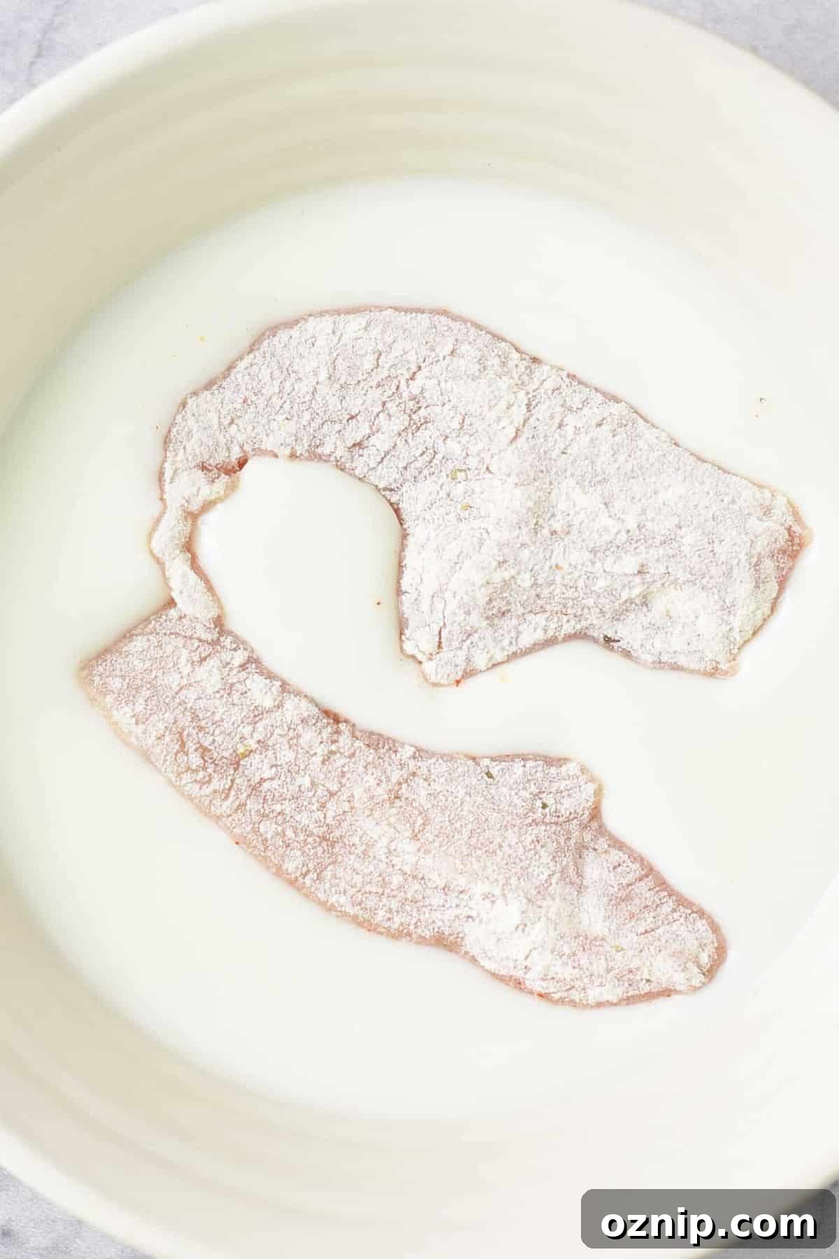 Dairy-Free Fried Chicken Recipe Flour-coated chicken strips in buttermilk.