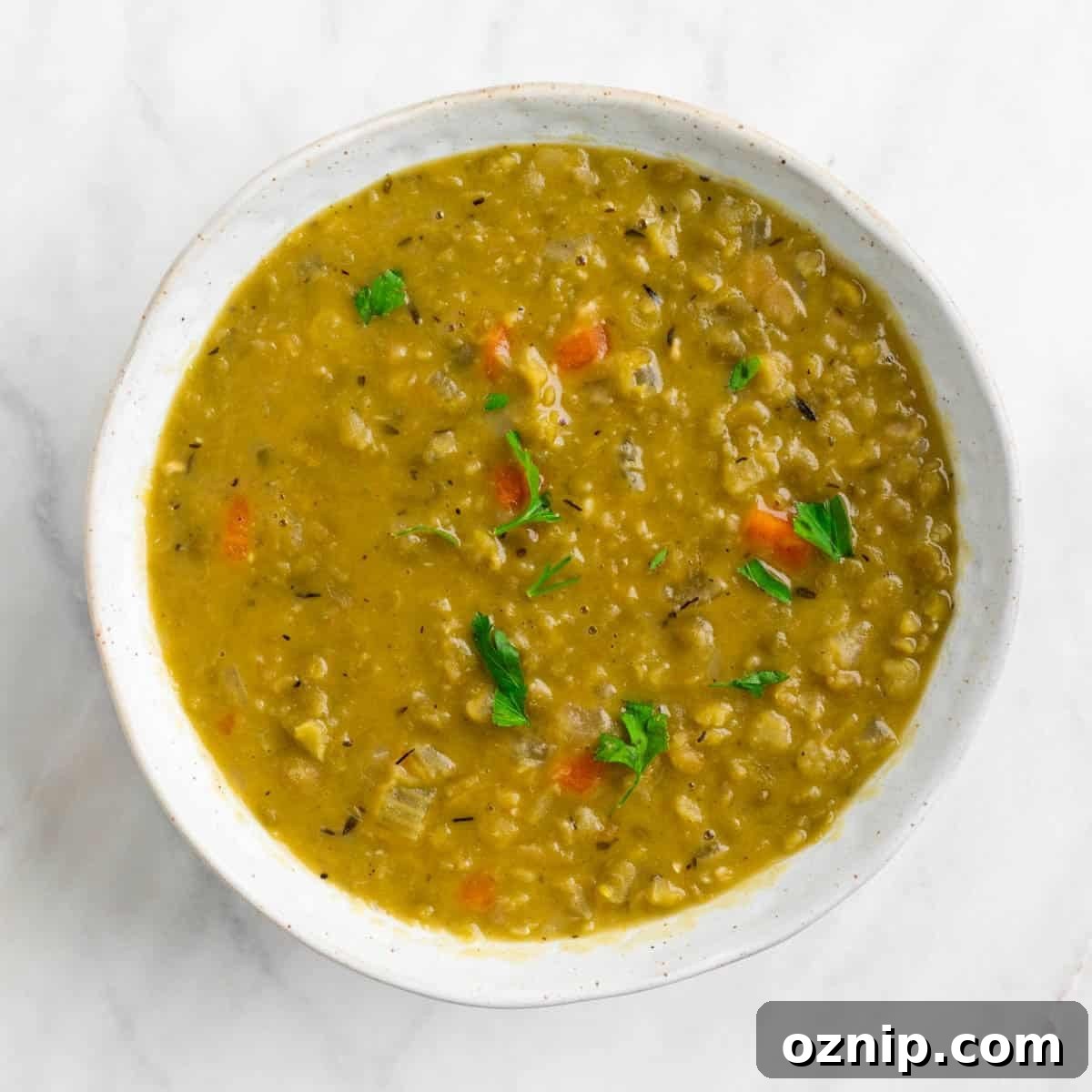 Hearty Vegan Split Pea Soup Recipe 7 Vegan split pea soup in a bowl garnished with parsley.