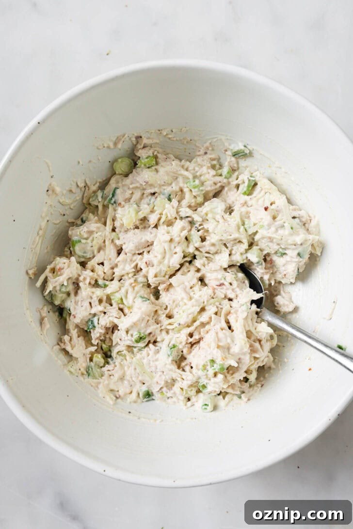 Shredded chicken added and mixed into mayo mixture ready to be made into sandwiches.
