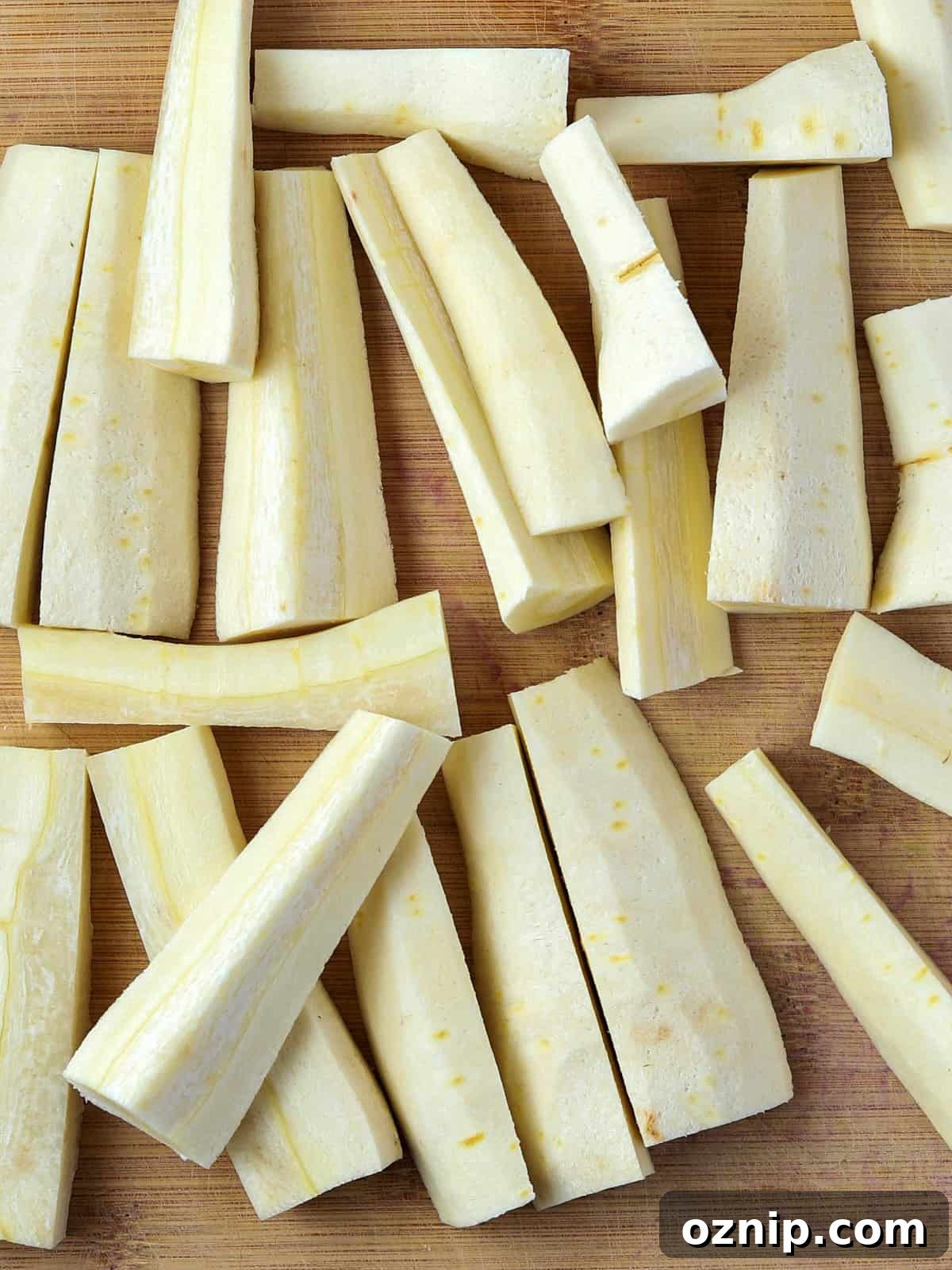 Photo of peeled and chopped parsnips on a chopping board.