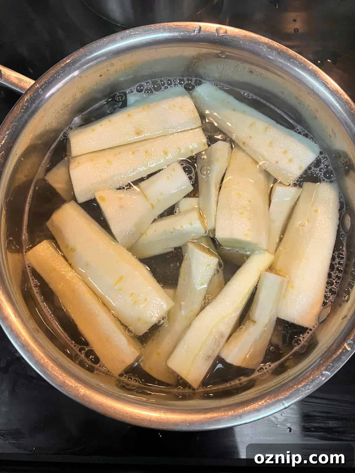 Photo of parsnips boiling in a pan of water.