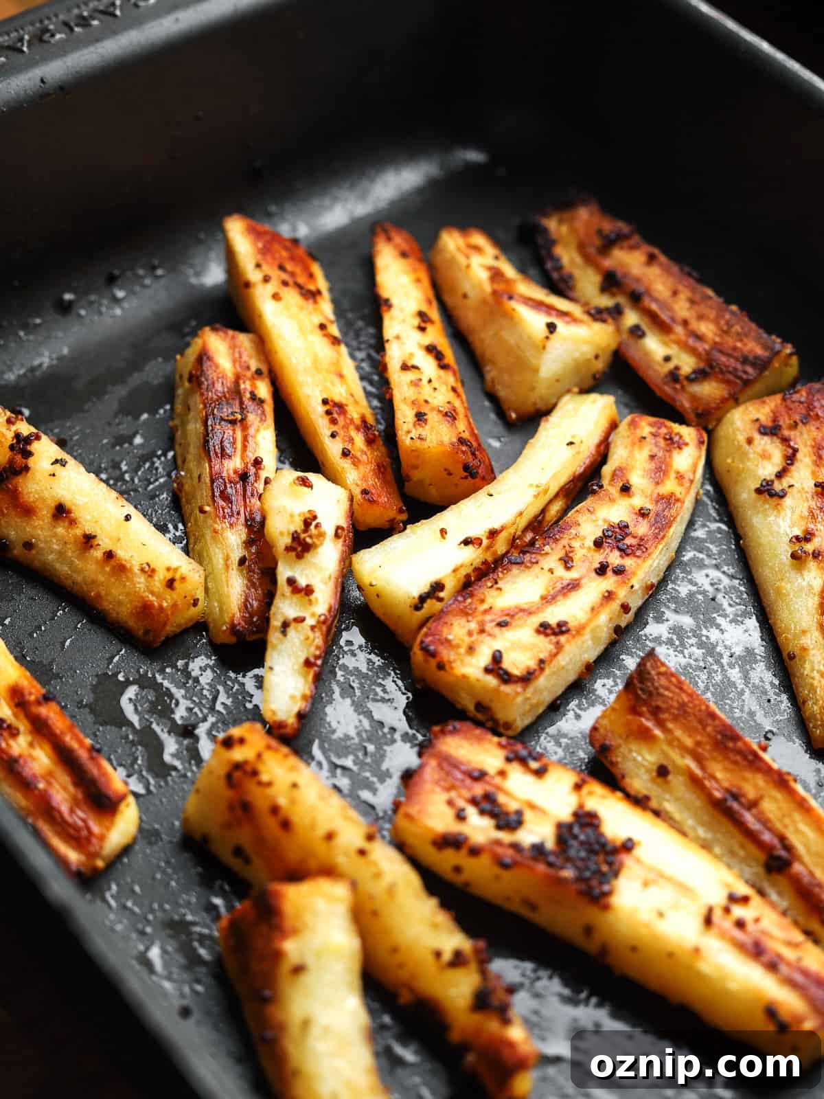 Photo of roasted parsnips in the roasting pan after roasting.