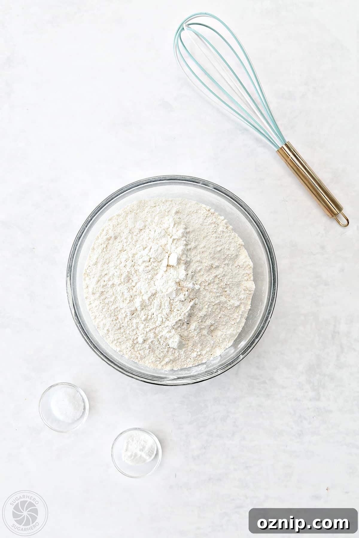 How to Make Watercolor Rose Sugar Cookies 7 Bowls of flour, salt, and baking powder next to a whisk for sugar cookies.
