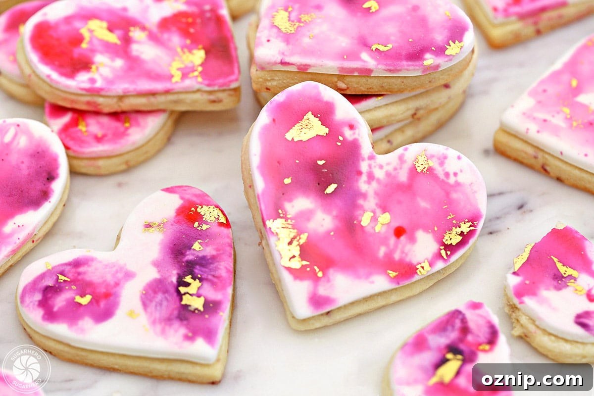 How to Make Watercolor Rose Sugar Cookies 10 Several Watercolor Rose Sugar Cookies on a marble surface.