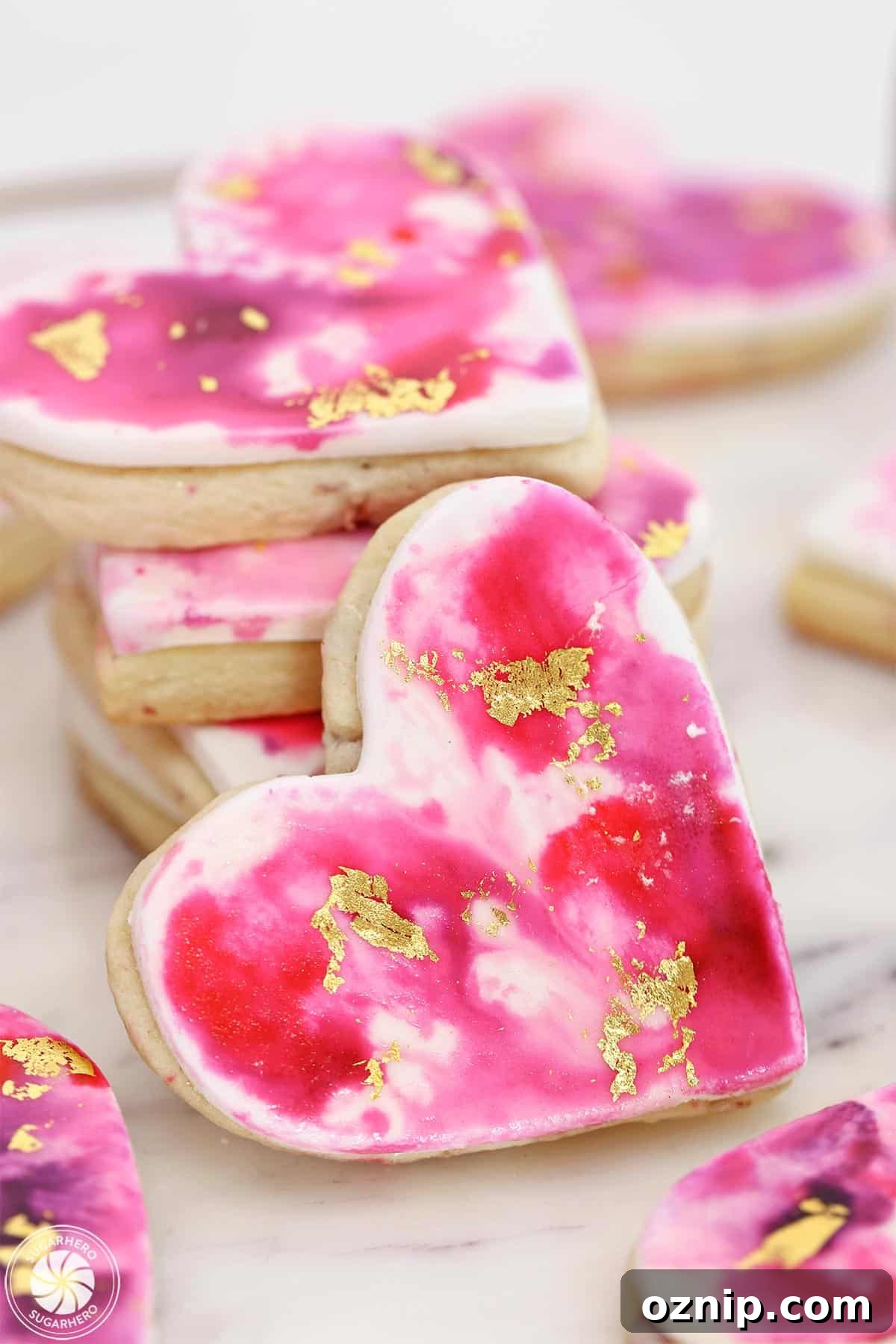 How to Make Watercolor Rose Sugar Cookies 6 A Watercolor Rose Sugar Cookie propped up next to a stack of more cookies.