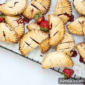 Roasted Strawberry Hand Pies on a cooling rack with fresh strawberries as garnish