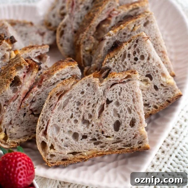 Slices of strawberry sourdough bread on a heart shaped plate with strawberries next to the bread.