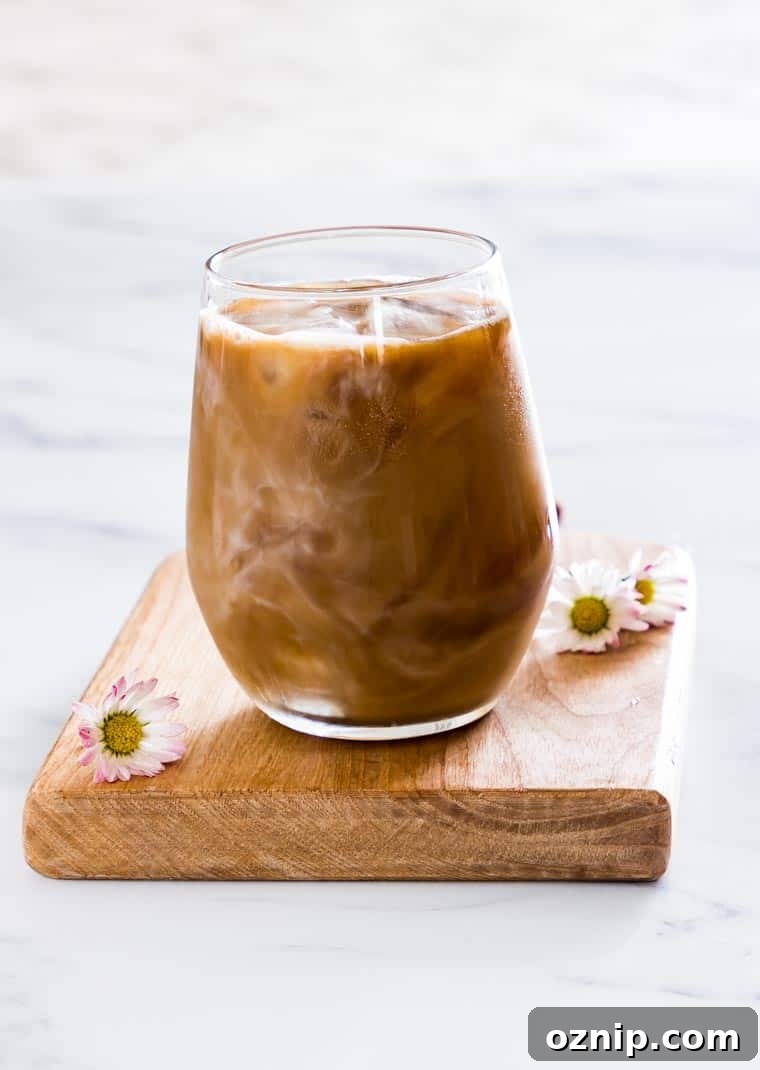 A Glass of Iced Coffee with flowers around it