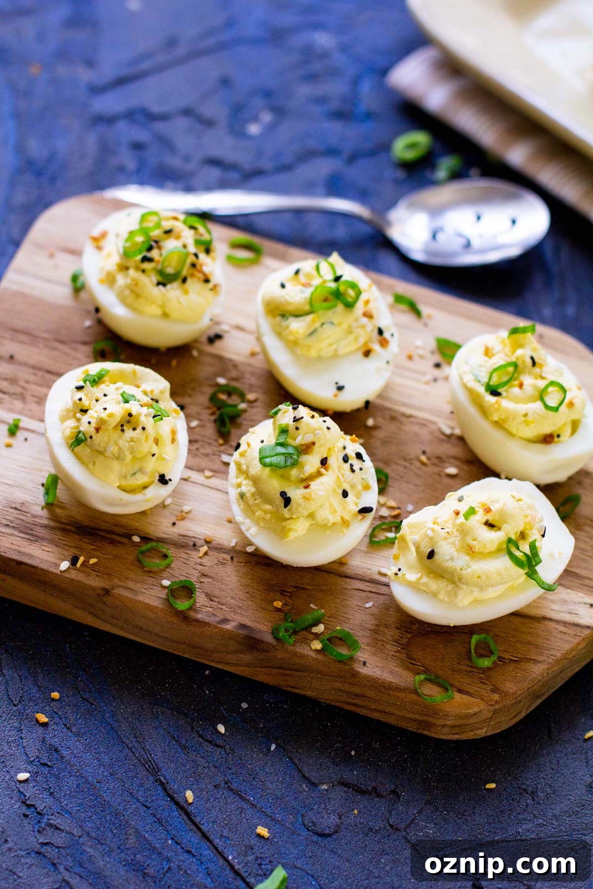 six completed instant pot deviled eggs on a wooden serving board