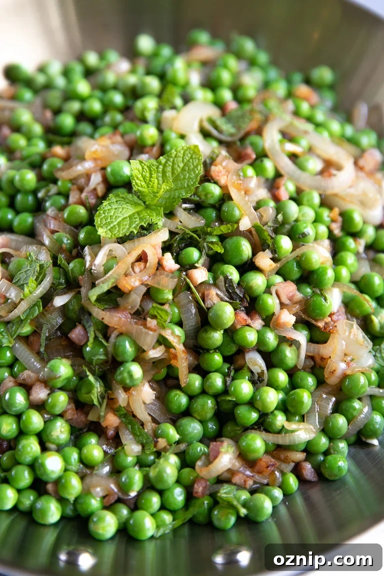 Peas and Pancetta Holiday Side Dish Recipe 2 Large skillet filled with sauteed pancetta and shallots with cooked sweet peas and garnished with mint.