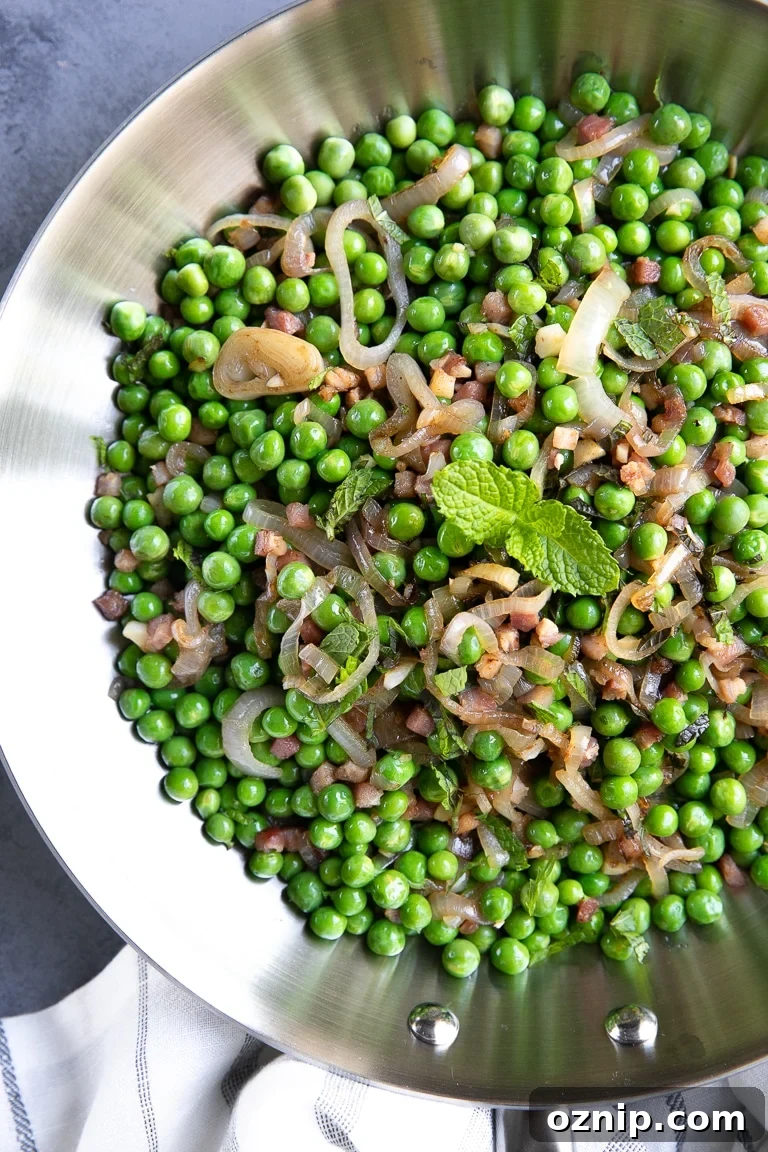Peas and Pancetta Holiday Side Dish Recipe 3 Large skillet filled with sauteed pancetta and shallots with cooked sweet peas and garnished with mint.