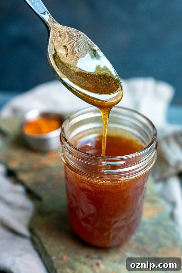 Spoon drizzling gochugaru hot honey.