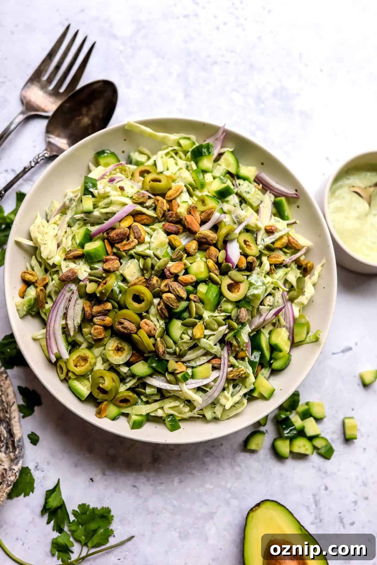 Green Goddess Salad Recipe with Creamy Avocado Herb Dressing 2 Green Goddess Salad recipe in a larger serving bowl with dressing to the side.