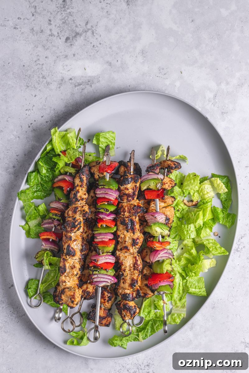 Greek Chicken Kebab Bowl with Tzatziki and Lemon Rice 10 shish kebab on a platter with greens.