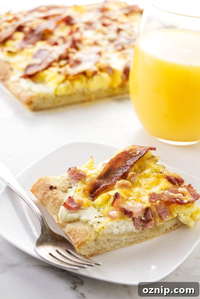A slice of breakfast pizza next to a glass of orange juice.