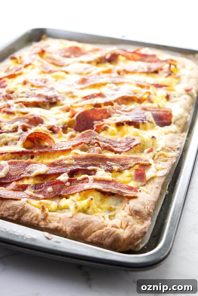 A bacon and egg pizza baked in a sheet pan.