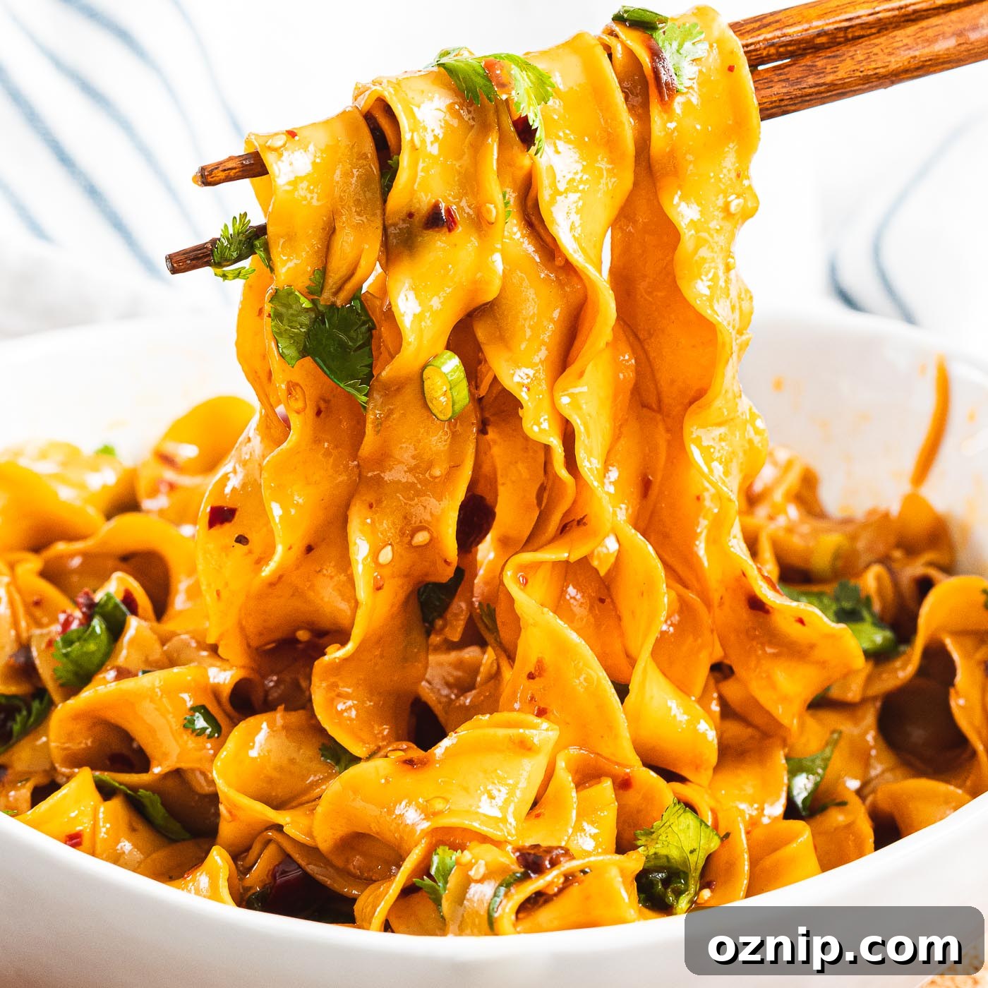 bowl of spicy Szechuan noodles with garlic chili oil and fresh herbs
