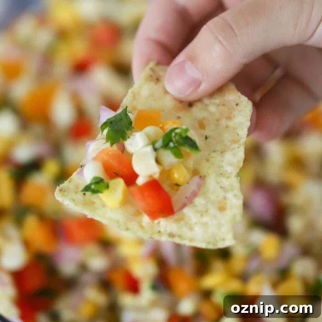 A tortilla chip with corn salsa.