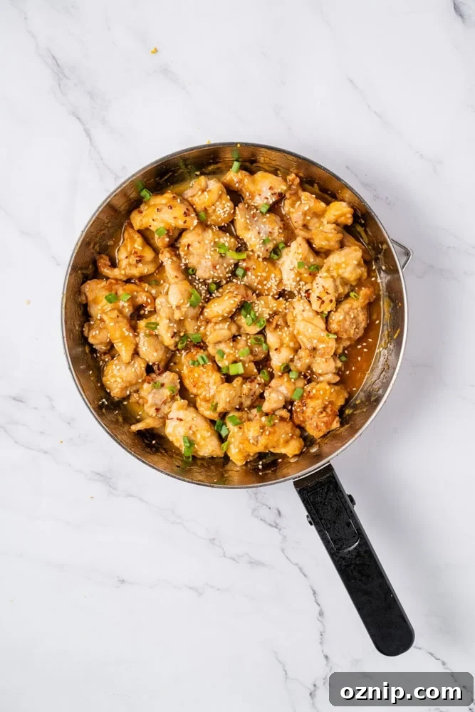 Final plated orange chicken with scallions.
