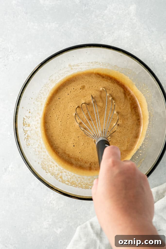 Whisking the wet ingredients in a glass mixing bowl.