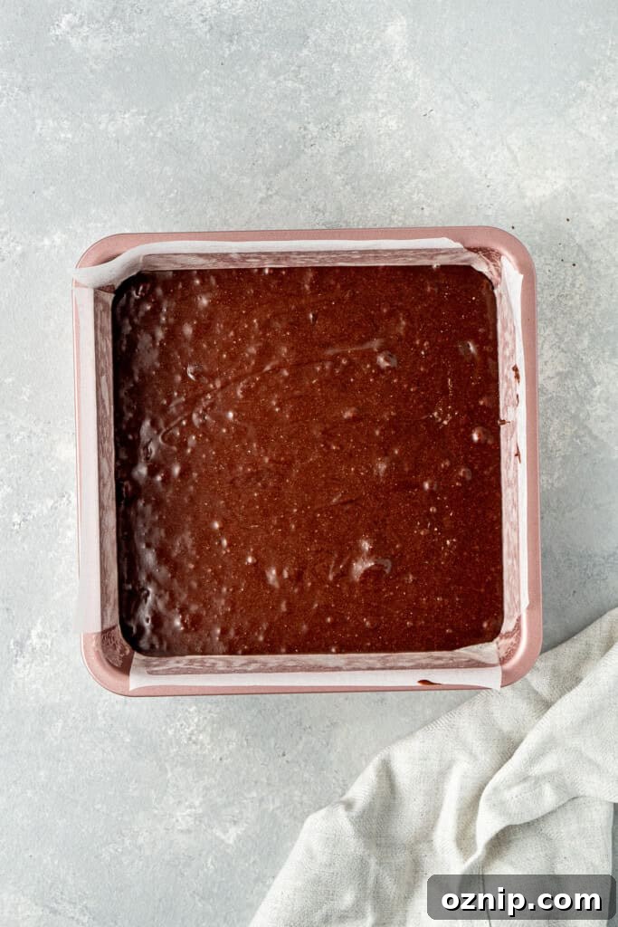 The brownie batter in a square baking pan.