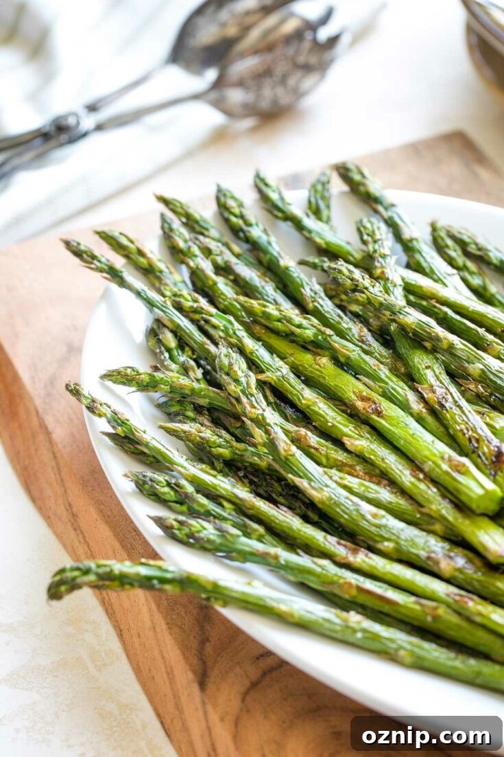 Top 10 Recipes of 2021: Most Popular Dishes Revealed 12 Roasted asparagus spears piled on a white serving platter.