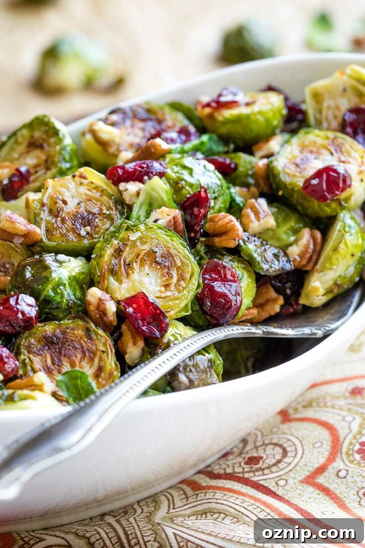 Top 10 Recipes of 2021: Most Popular Dishes Revealed 16 Side view of finished roasted Brussel sprouts in a white dish with a patterned cloth.