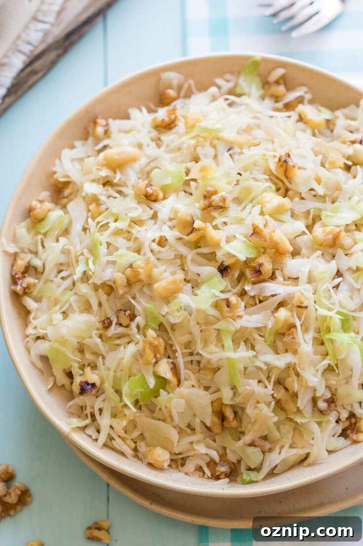 Top 10 Recipes of 2021: Most Popular Dishes Revealed 7 Tan serving bowl of sautéed cabbage garnished with walnuts.
