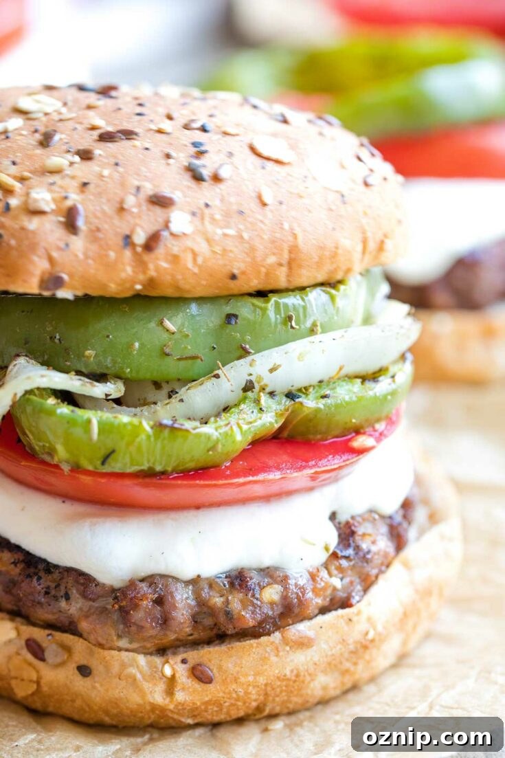 Top 10 Recipes of 2021: Most Popular Dishes Revealed 8 Closeup of a completed hamburger topped with Italian vegetables, cheese and bun.