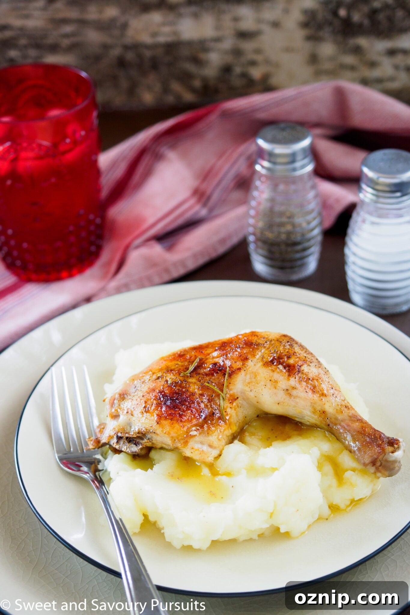 Juicy One Pan Roast Chicken with Garlic and Herbs 2 Roast chicken leg served on top of mashed potatoes.