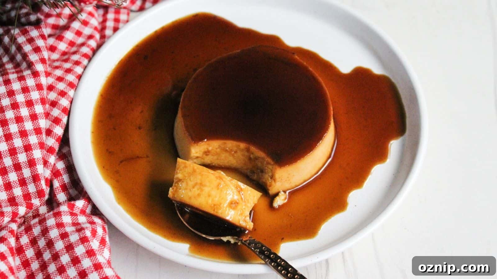 A slice of budget-friendly flan with caramel sauce on a white plate.