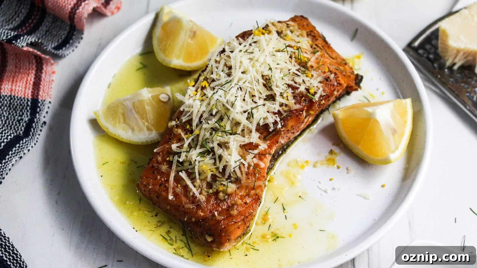 A plate of salmon on a white plate with lemon slices on it.