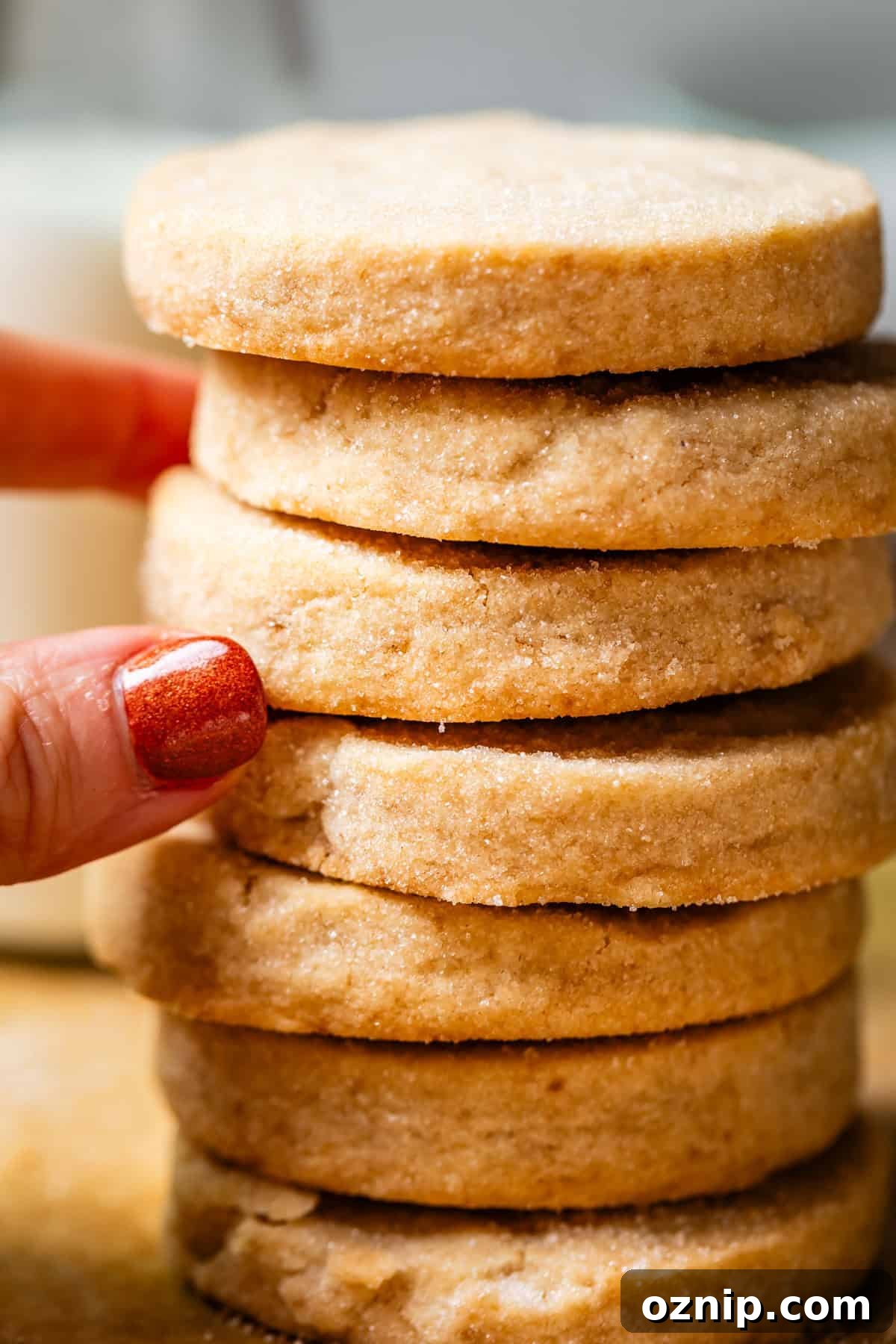 Classic Homemade Buttery Shortbread Cookies 6 stack of round shortbread cookies with fingers pulling at the center cookies.
