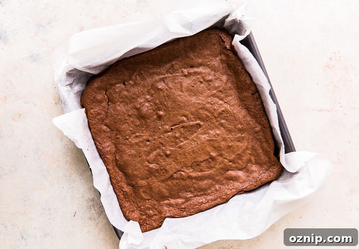 cake brownies in a parchment paper lined square pan after baking