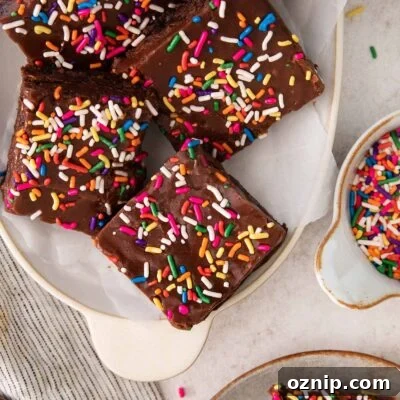 Fudgy Gluten-Free Birthday Brownies Recipe 8 fudge-frosted brownies topped with sprinkles on a platter.