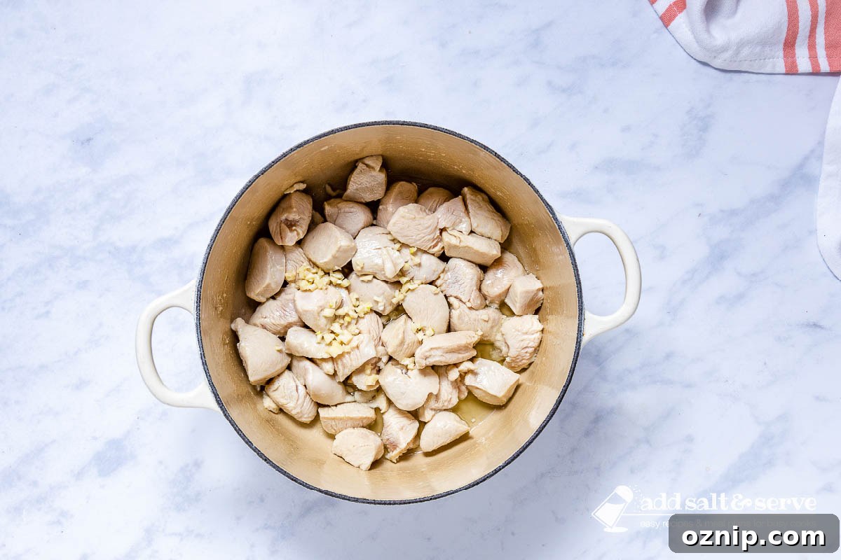 Southwest Chicken Corn Chowder Recipe 4 Enameled Dutch oven with sautéed chicken and with minced garlic just added.
