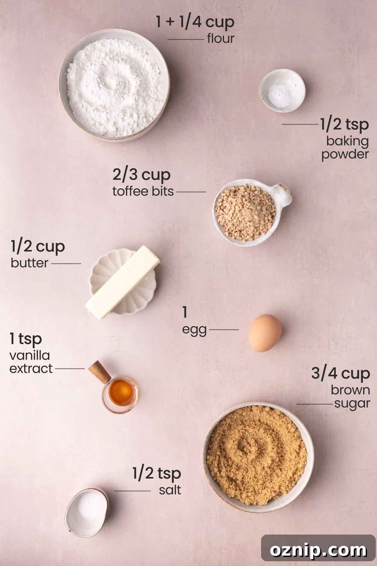 Buttery Crunch Cookies: Chewy Centers, Crispy Edges 3 Overhead view of the ingredients needed for butter crunch cookies - flour, baking powder, toffee bits, butter, egg, vanilla extract, brown sugar, and salt.