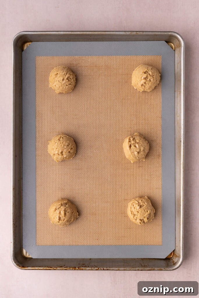Buttery Crunch Cookies: Chewy Centers, Crispy Edges 10 Butter crunch cookie dough on a lined baking sheet ready to bake in the oven.