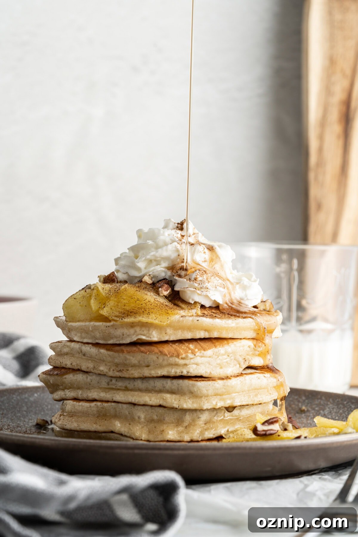 drizzling syrup onto apple pancakes