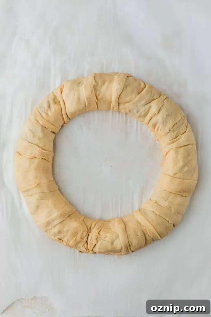 Flaky Bacon and Brie Crescent Wreath Recipe 10 A bread wreath on parchment paper.