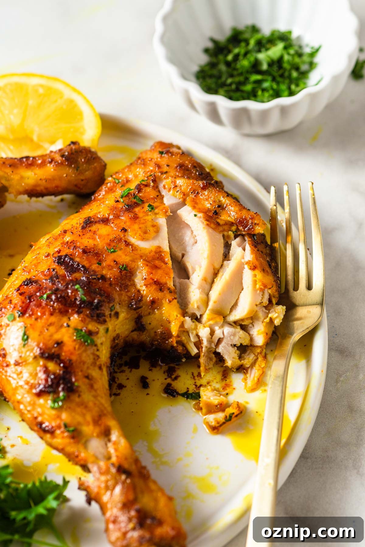 air fryer chicken leg quarter sliced with a fork.