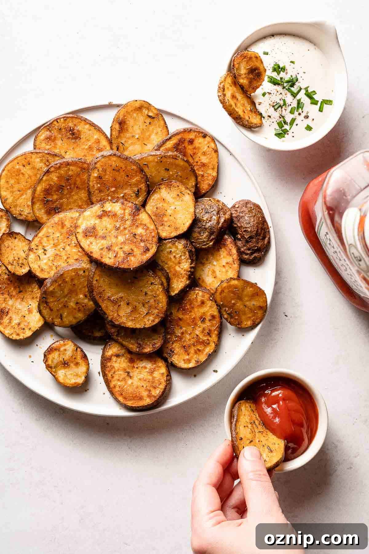 plate of cottage fries with hand dipping one in ketchup