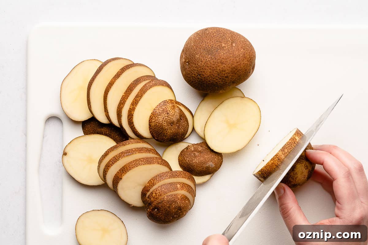 potato being sliced thinly with large knife