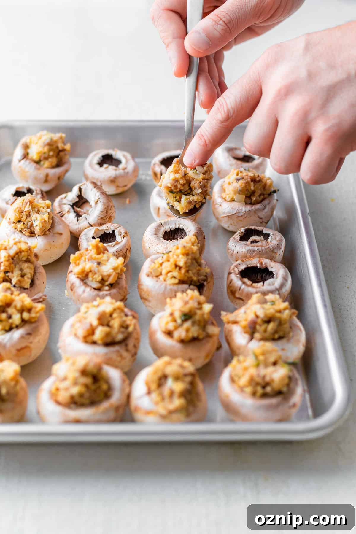 mushroom caps being filled with cream cheese filling for cream cheese stuffed mushrooms