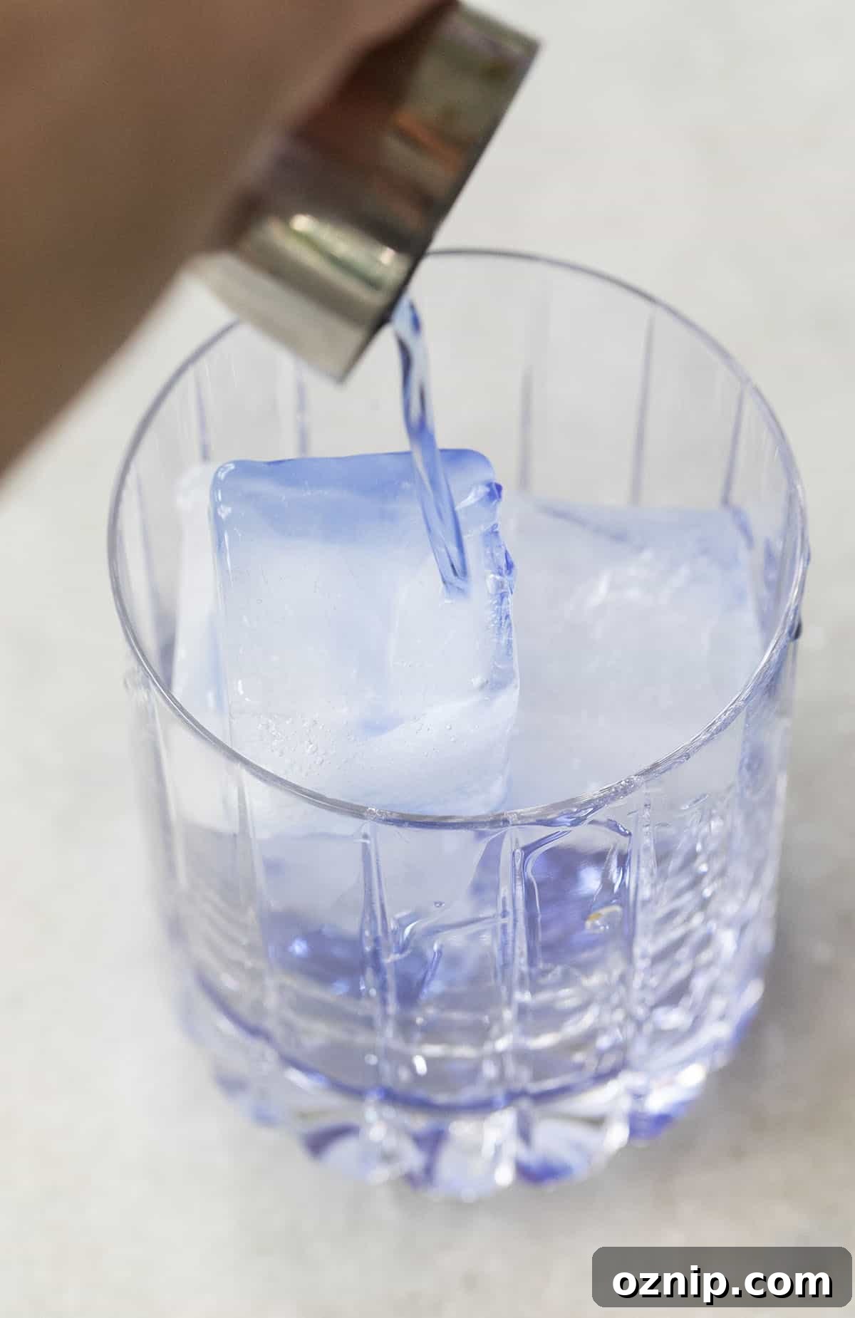 Empress Gin Cocktails for Stunning Color Changing Drinks 6 pouring blue spirit into a glass filled with ice