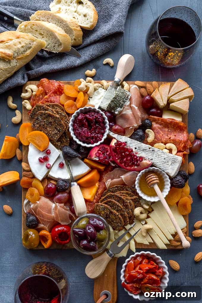 Overhead view of a fully assembled cheese board with bread and wine off to the side.