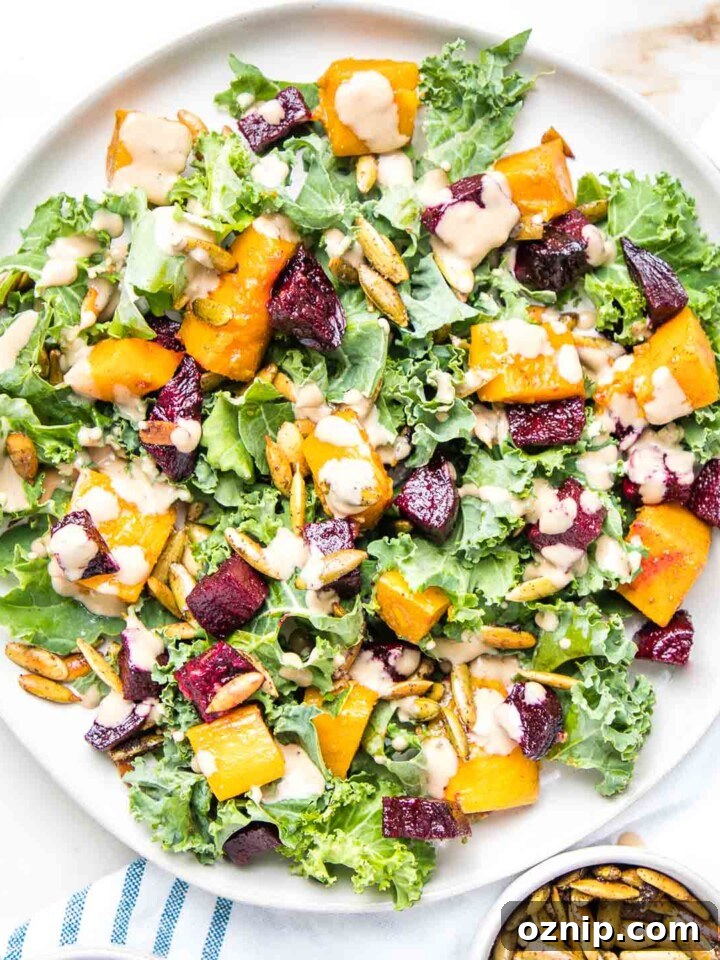 Large plate filled with kale, roasted butternut squash and beets, toasted pumpkin seeds and creamy balsamic dressing.