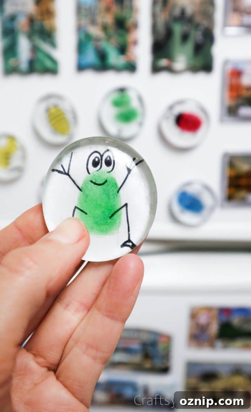 DIY Fingerprint Glass Magnets for Kids Keepsakes 2 holding glass magnet with frog figure