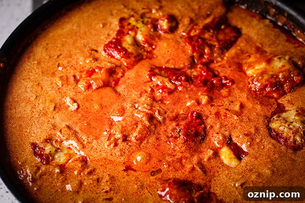 A pan of Chicken Paprikash cooking on the stovetop.